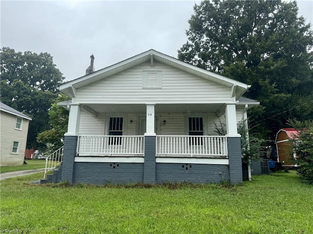 bungalow-style home with a front lawn and covered porch