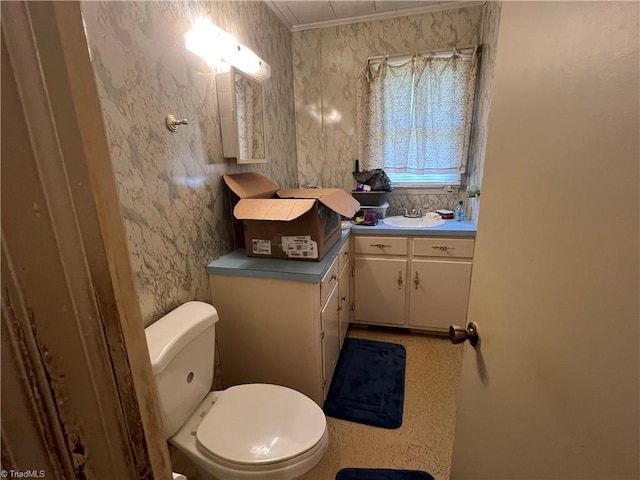 bathroom with toilet, crown molding, and vanity