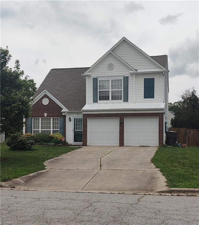 3855 Windstream Way, Jamestown, NC 27282 - traditional-style home featuring a garage, concrete driveway, and brick siding