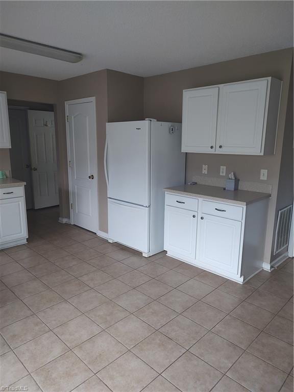 3855 Windstream Way, Jamestown, NC 27282 - kitchen featuring freestanding refrigerator, white cabinets, light countertops, baseboards, and light tile patterned floors