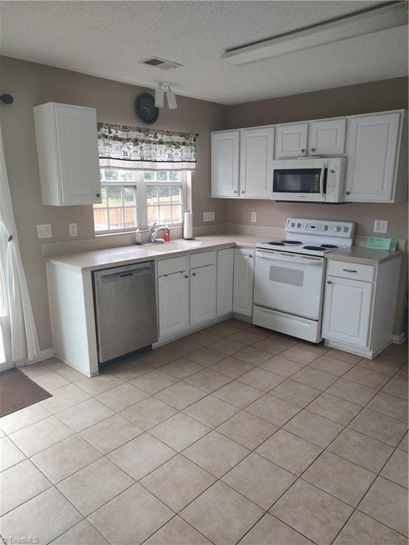 3855 Windstream Way, Jamestown, NC 27282 - kitchen featuring white appliances, light countertops, a sink, and a textured ceiling