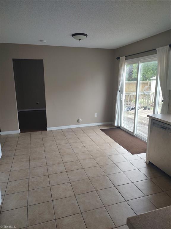 3855 Windstream Way, Jamestown, NC 27282 - empty room with baseboards, a textured ceiling, and light tile patterned flooring