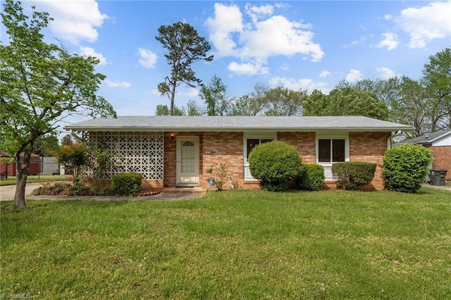ranch-style home featuring a front lawn and brick siding