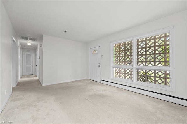 unfurnished living room with carpet, visible vents, a baseboard heating unit, baseboards, and attic access