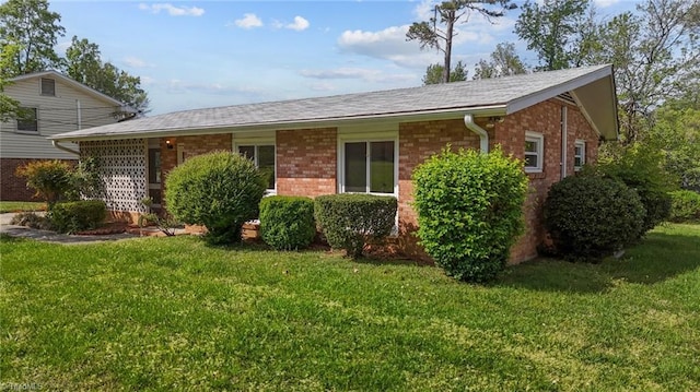 view of front of house featuring brick siding and a front yard