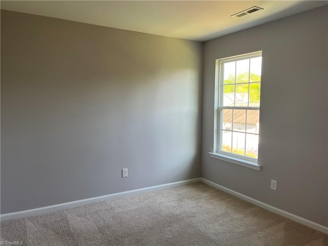 unfurnished room with visible vents, carpet flooring, and baseboards
