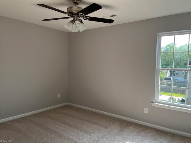 spare room featuring carpet floors, a ceiling fan, baseboards, and a healthy amount of sunlight