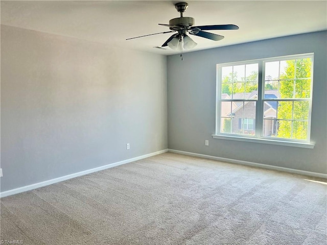 carpeted empty room with baseboards and ceiling fan