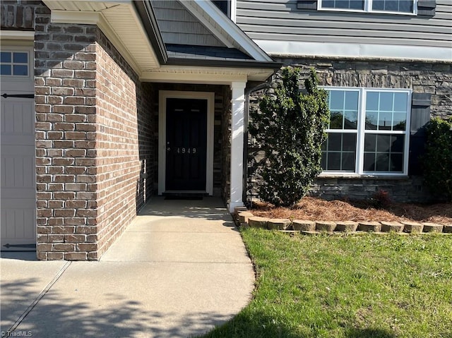 entrance to property featuring brick siding and stone siding