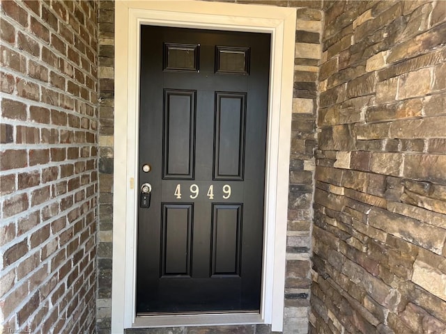doorway to property featuring brick siding
