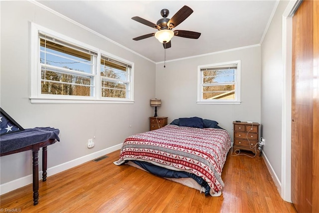 bedroom with ornamental molding, ceiling fan, and wood-type flooring