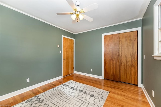 bedroom featuring ceiling fan, light hardwood / wood-style floors, ornamental molding, and a closet