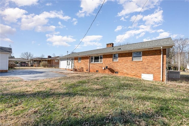 rear view of property featuring a patio and a lawn