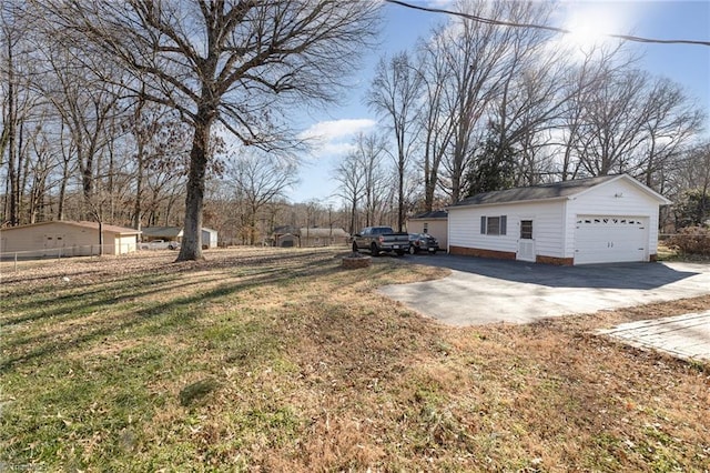 view of side of home featuring a garage, an outdoor structure, and a lawn