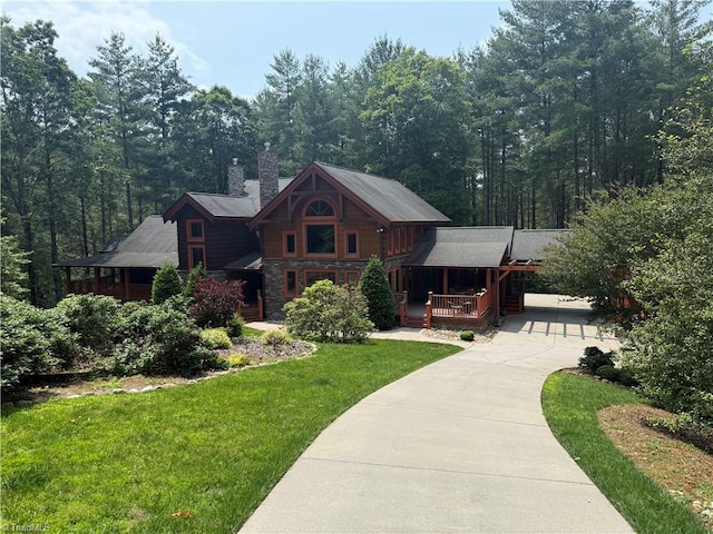 5626 Rocky Falls Ln, Lenoir, NC 28645 - view of front of property with a front lawn, a chimney, concrete driveway, covered porch, and stone siding