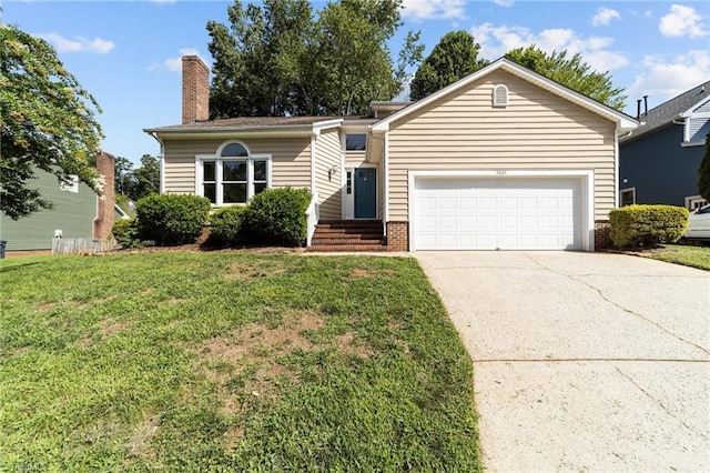 view of front of house with a chimney, a front lawn, driveway, brick siding, and a garage