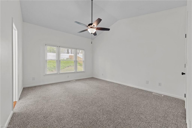 empty room featuring lofted ceiling, baseboards, a ceiling fan, and carpet flooring