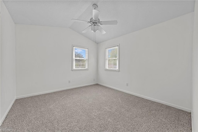 empty room with vaulted ceiling, baseboards, carpet, and ceiling fan