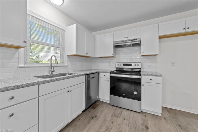 kitchen with under cabinet range hood, stainless steel appliances, white cabinetry, and a sink