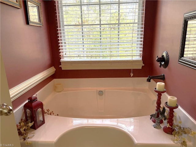 bathroom featuring plenty of natural light and a bath