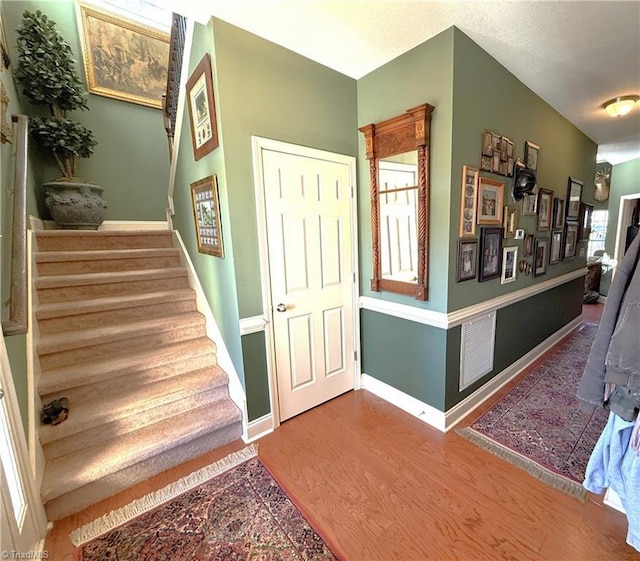 staircase with baseboards and wood finished floors