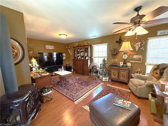 living area with ceiling fan, visible vents, and wood finished floors