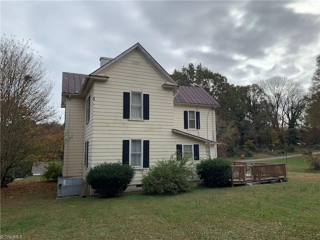 back of house featuring a deck and a yard