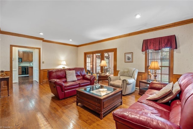 living room with a wealth of natural light, wood finished floors, and wainscoting