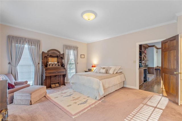 carpeted bedroom with ornamental molding and baseboards