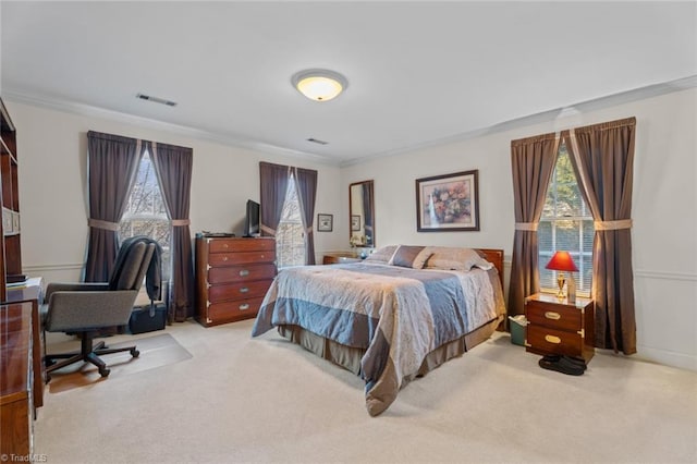 carpeted bedroom featuring visible vents and ornamental molding