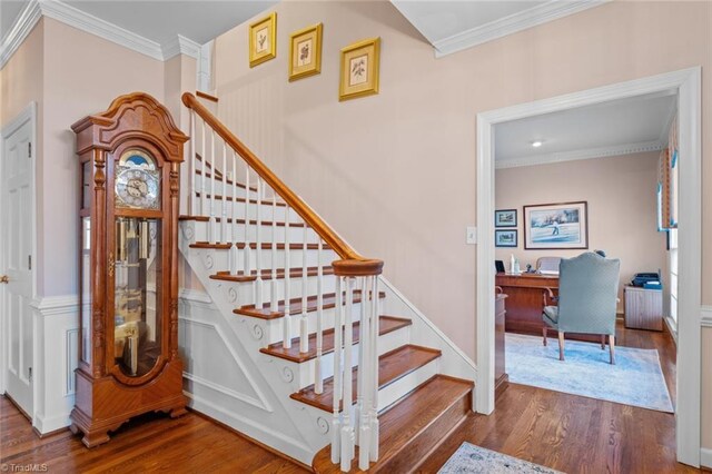 staircase with baseboards, ornamental molding, and wood finished floors