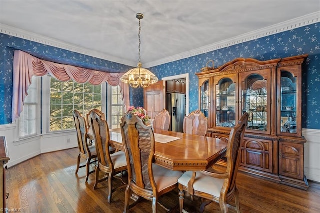 dining area featuring a chandelier, crown molding, wood-type flooring, and wallpapered walls