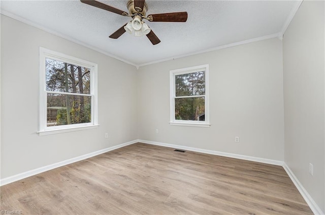 unfurnished room with ornamental molding, ceiling fan, a wealth of natural light, and light hardwood / wood-style floors