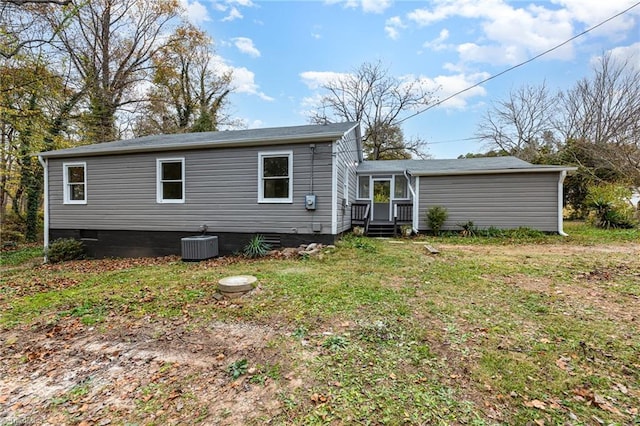 back of property with cooling unit and a yard