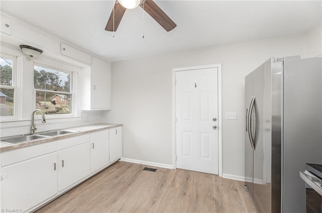 kitchen with white cabinetry, sink, appliances with stainless steel finishes, ceiling fan, and light wood-type flooring