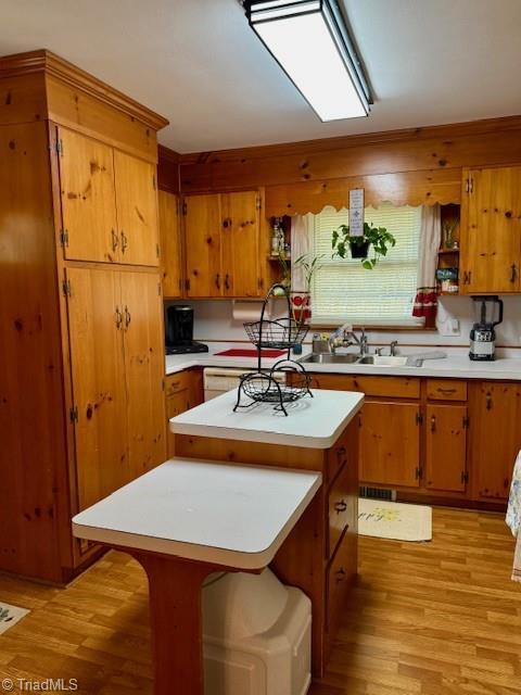 kitchen with light wood-type flooring, a center island, a breakfast bar area, and sink