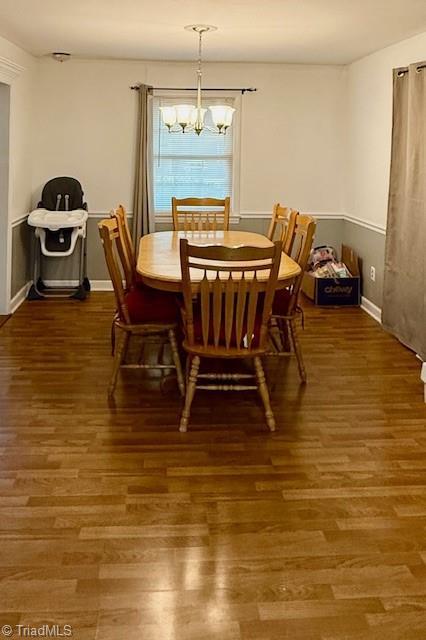 dining room featuring a chandelier and dark wood-type flooring