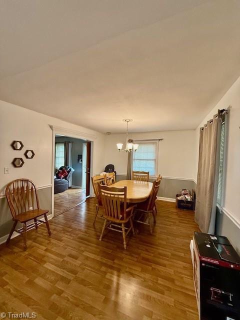 dining space featuring hardwood / wood-style floors and a chandelier