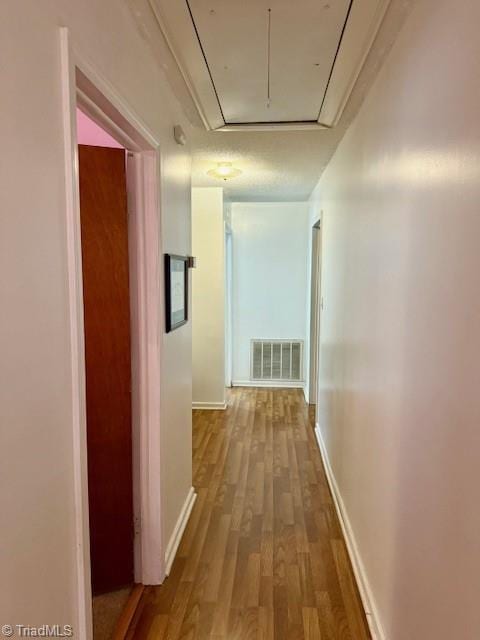 corridor with hardwood / wood-style flooring