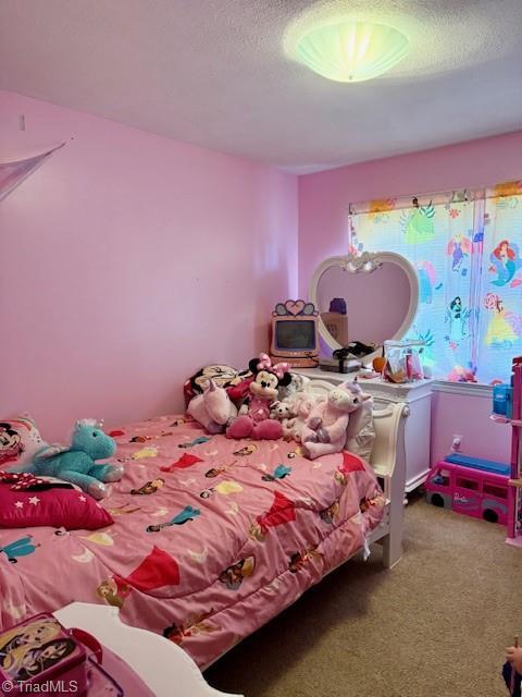 bedroom featuring carpet floors and a textured ceiling