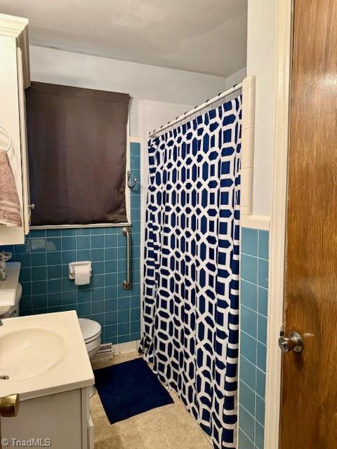 bathroom featuring a shower with curtain, vanity, tile walls, and toilet