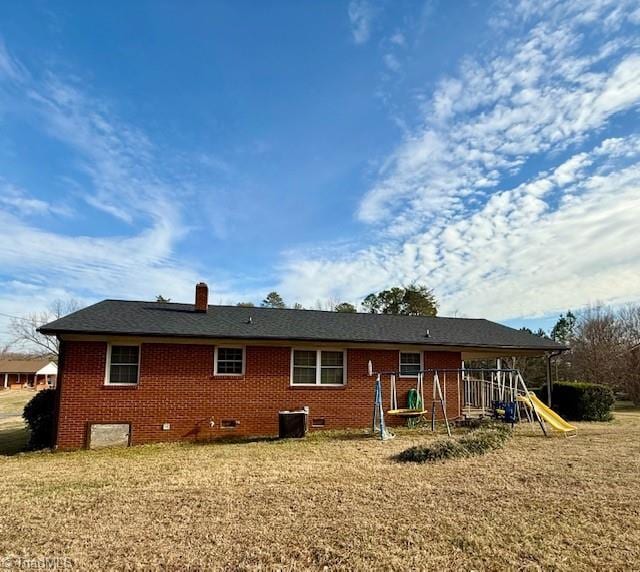 back of house featuring a playground and central air condition unit