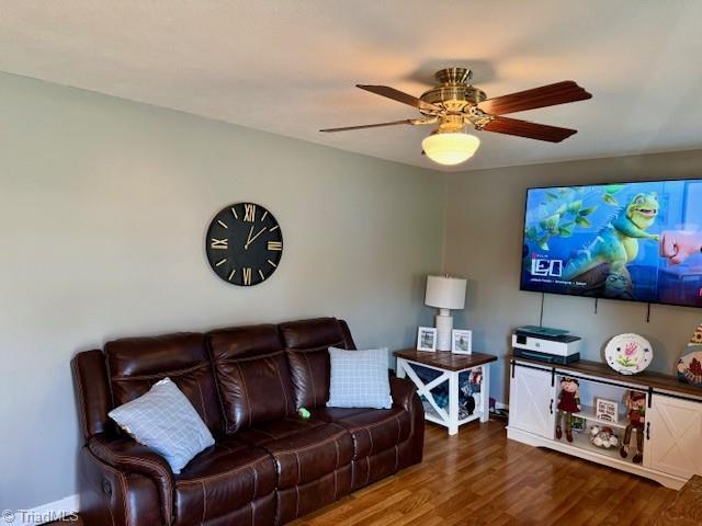 living room with dark hardwood / wood-style floors and ceiling fan