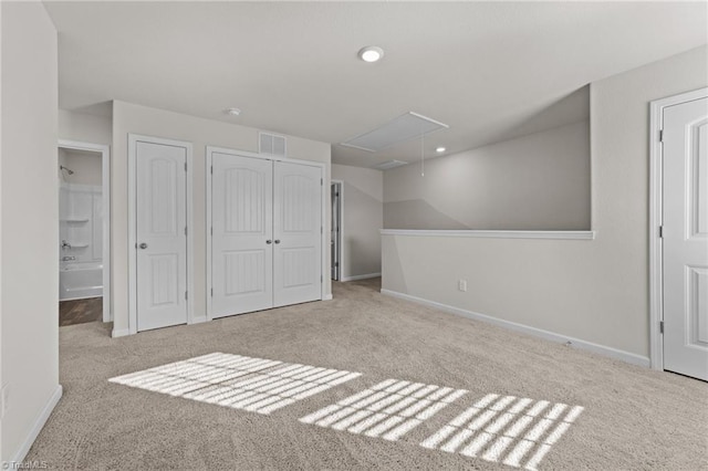 unfurnished bedroom with two closets and light carpet