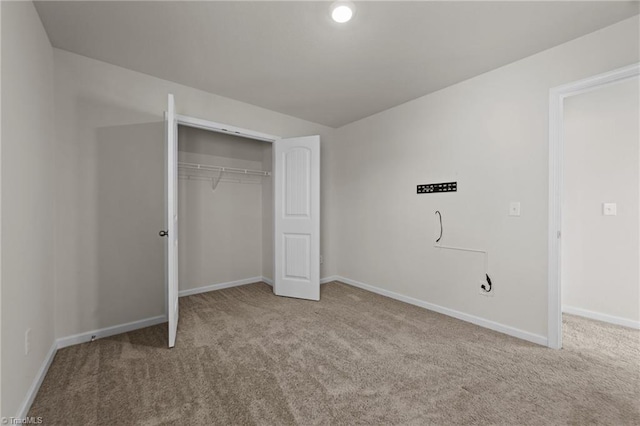 unfurnished bedroom with light carpet and a closet