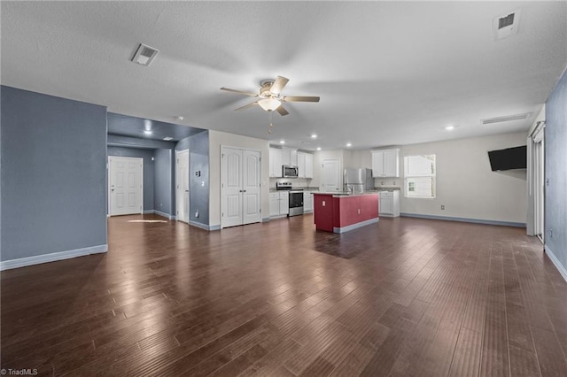 unfurnished living room featuring sink, dark hardwood / wood-style floors, and ceiling fan