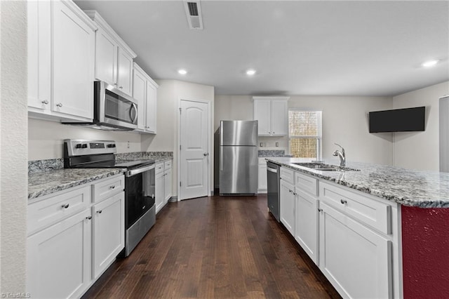 kitchen featuring appliances with stainless steel finishes, sink, white cabinets, and dark hardwood / wood-style flooring