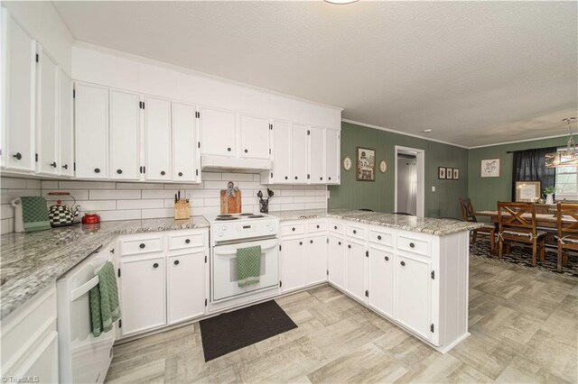 kitchen with kitchen peninsula, light stone countertops, backsplash, white cabinets, and white electric range