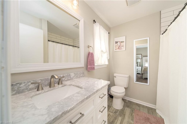 bathroom featuring toilet, vanity, vaulted ceiling, and hardwood / wood-style flooring