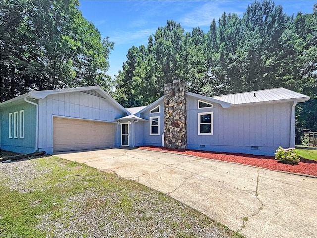 6630 Riverwood Rd, Walkertown, NC 27051 - mid-century modern home featuring crawl space, a garage, driveway, a metal roof, and a chimney